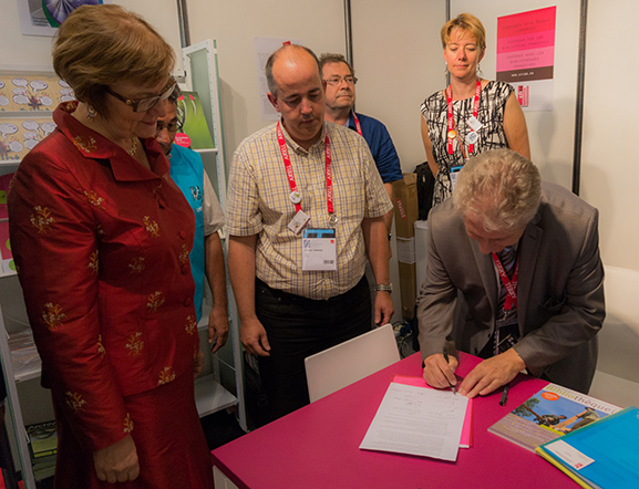 Pascal Sanz (CFI-bd) firma la declaración WIPO de asociaciones francesas con la Presidenta de la IFLA Sinikka Sipilä y Xavier Galaup de IABD como testigos
