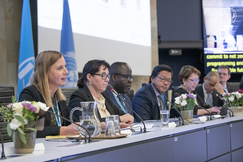 53393821809 fa58c755f7 c Panel of eight people, with a blonde woman speaking in the foreground, with flowers and water on the table, and a UN and ITU flag behind