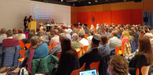 Symposium participants seated in an auditorium