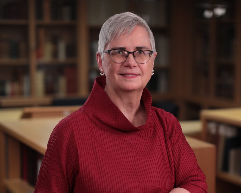 Leslie Weir [portrait in red dress with glasses]